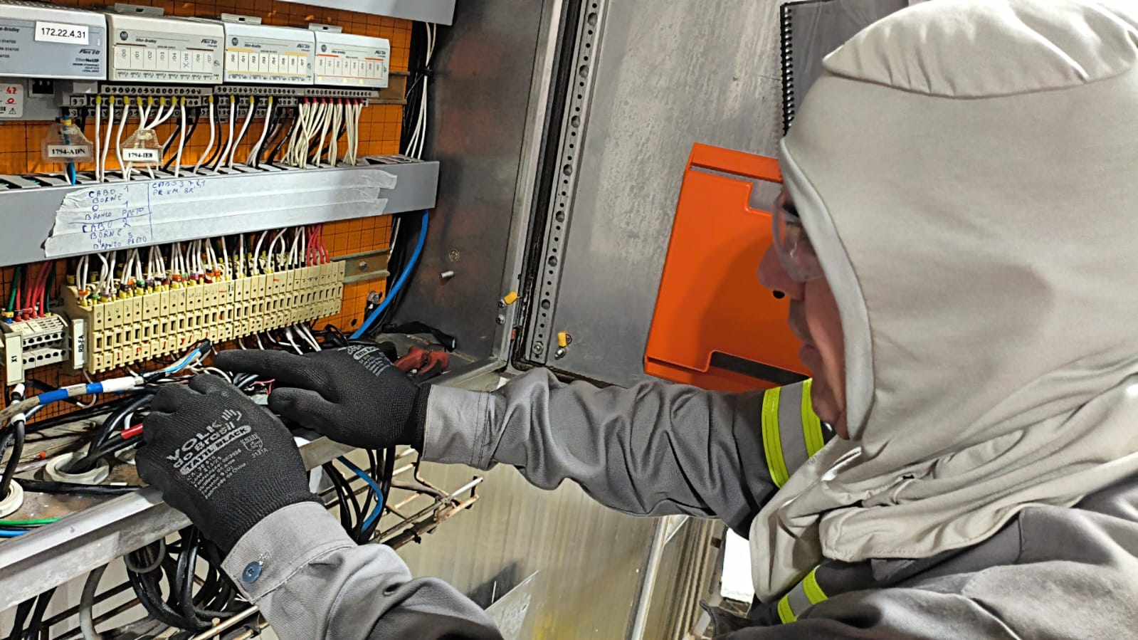 Profissional realizando ligação em painel elétrico
